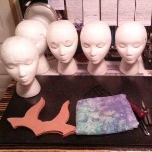 Leather crowns, and styrofoam heads, on a desk.